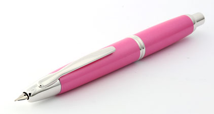 Carnet, stylo plume, lunettes et succulent sur fond rose pour
